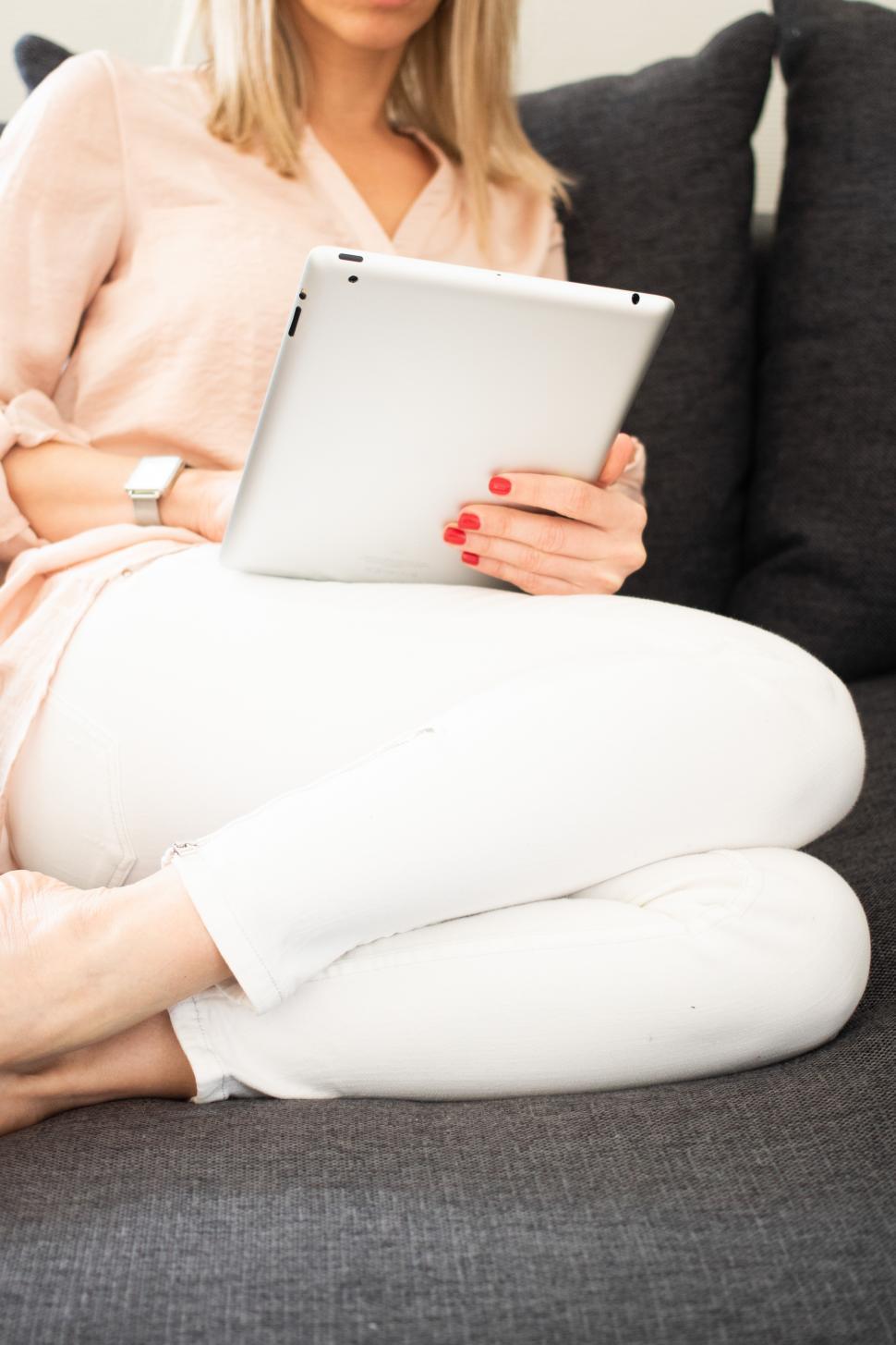 Free Image of Woman with tablet relaxing on couch in modern living room 