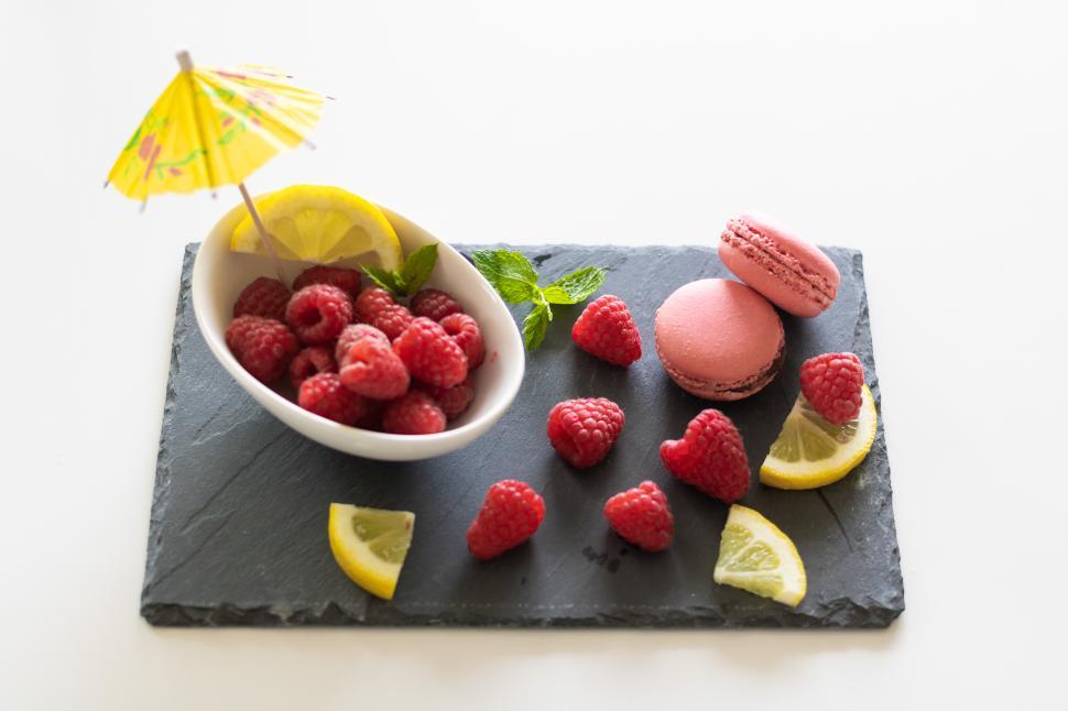 Free Image of Fresh raspberries and macaroons served on slate with decorative elements 