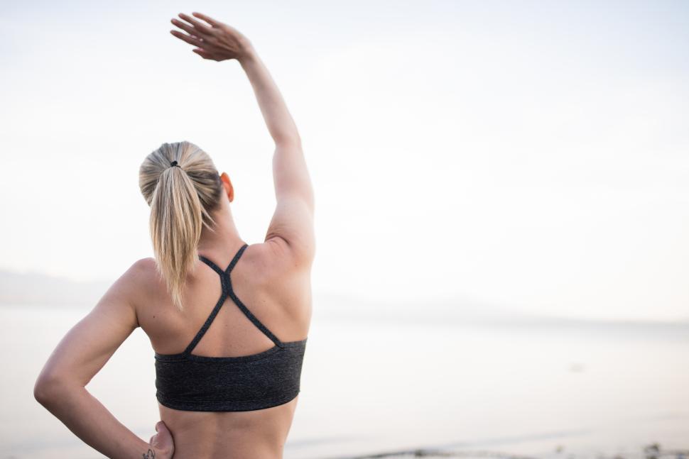 Free Image of Outdoor stretching session by the water at sunrise 