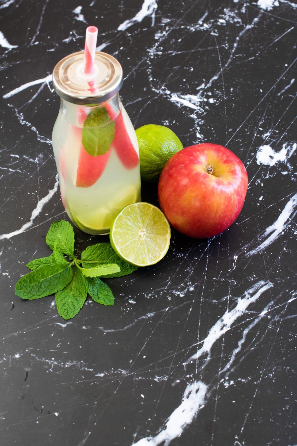 Free Image of Refreshing drink with lime, apple, and mint on countertop 