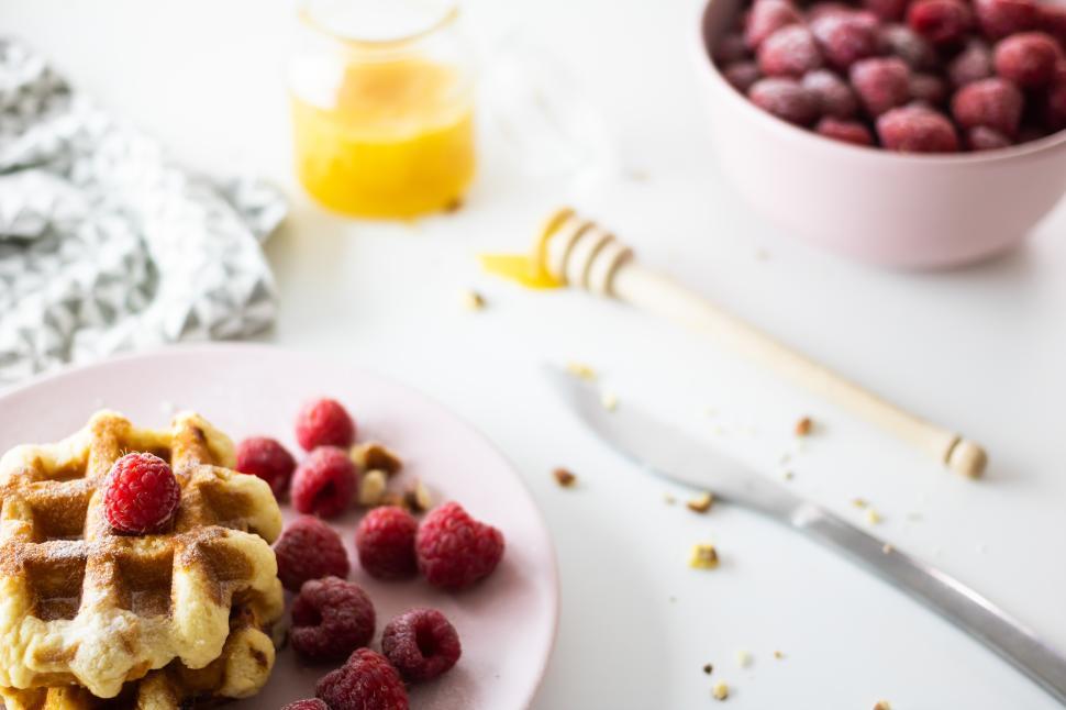Free Image of Delicious waffles topped with fresh raspberries and honey 