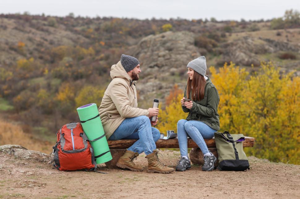 Free Image of Couple enjoys warm drinks during outdoor camping trip in autumn 