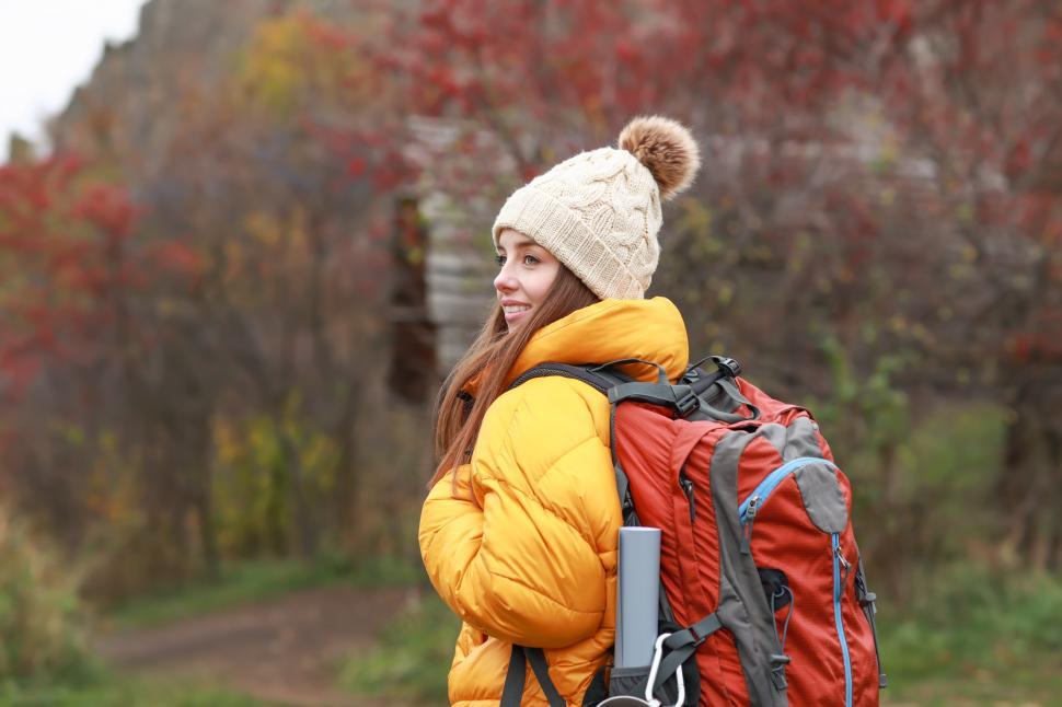 Free Image of Woman hiking with backpack in autumn forest setting 