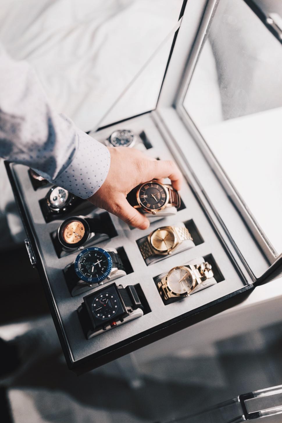 Free Image of Selecting a stylish watch from a display case at a store 