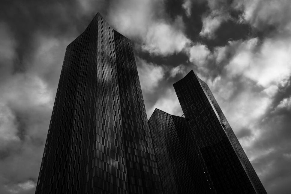 Free Image of Cloudy skyline with modern skyscrapers rising against an overcast sky 