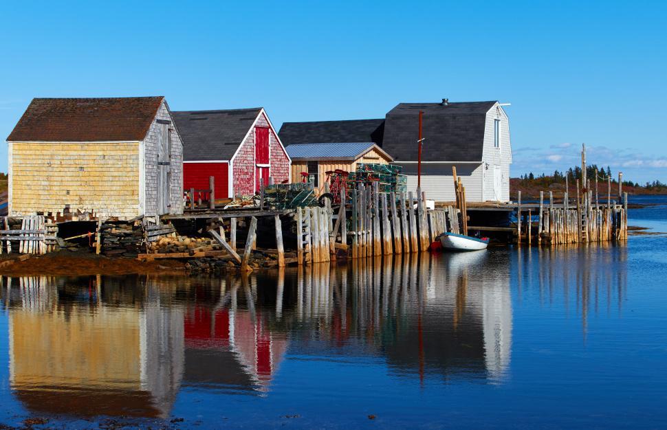 Free Image of Charming coastal buildings reflect in calm water 