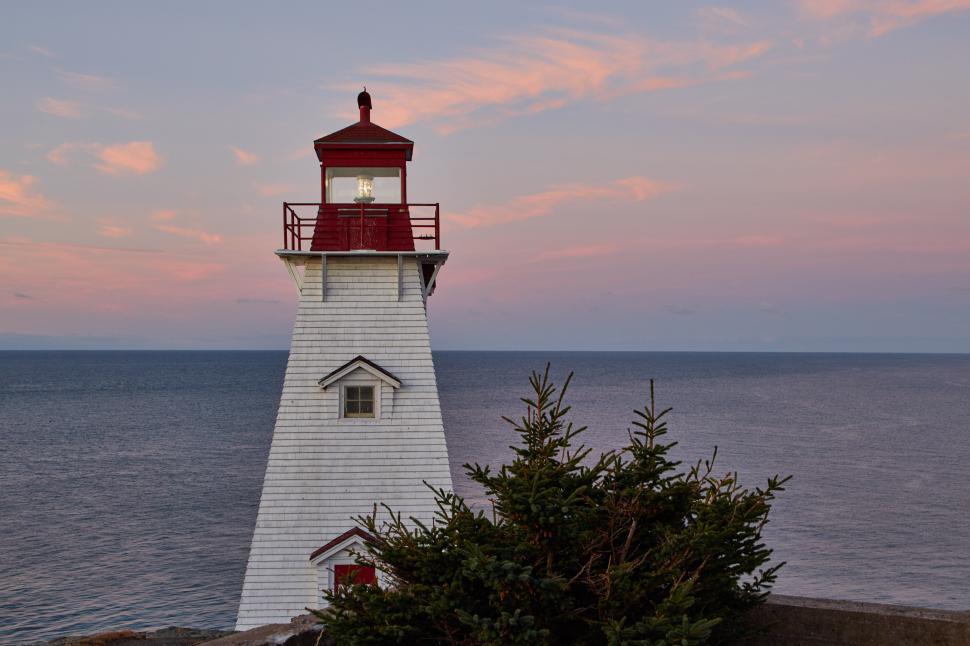 Free Image of Beautiful lighthouse by the sea at sunset 