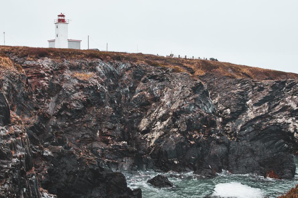 Free Image of Coastal view with lighthouse and rocky shoreline 