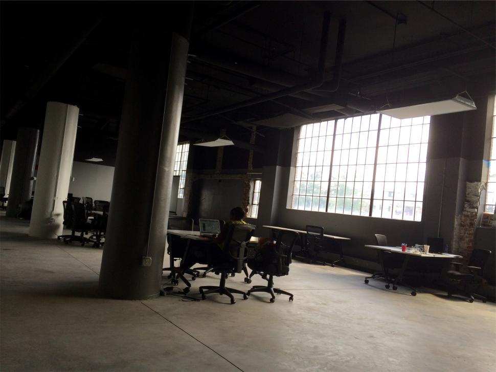 Free Image of Empty office space with workstations and large windows during the day 
