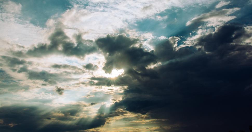 Free Image of Cloudy sky with sunlight peeking through in the afternoon 