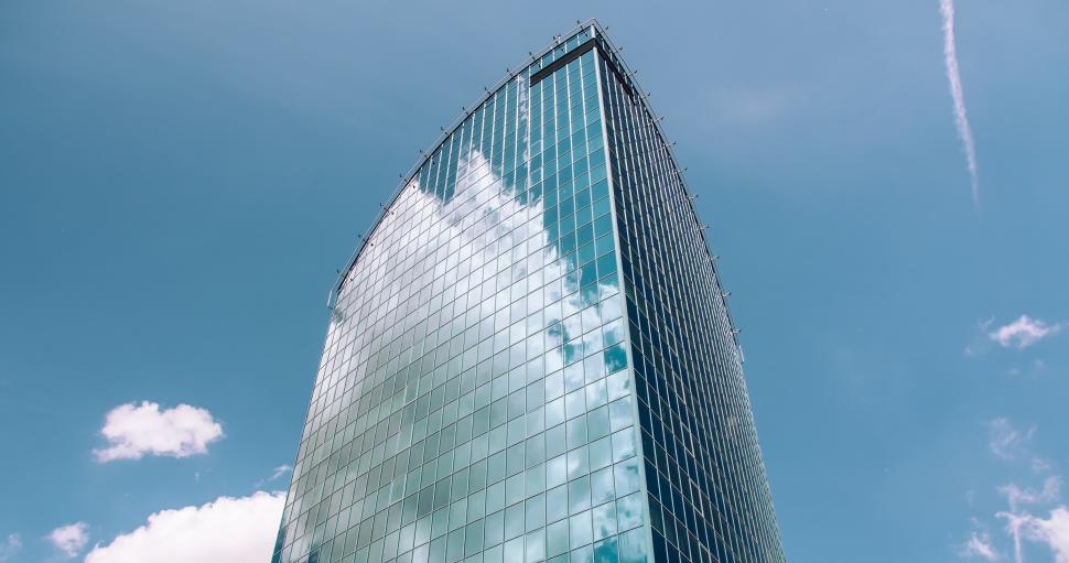 Free Image of Modern skyscraper reflecting clouds in bright sunlight 