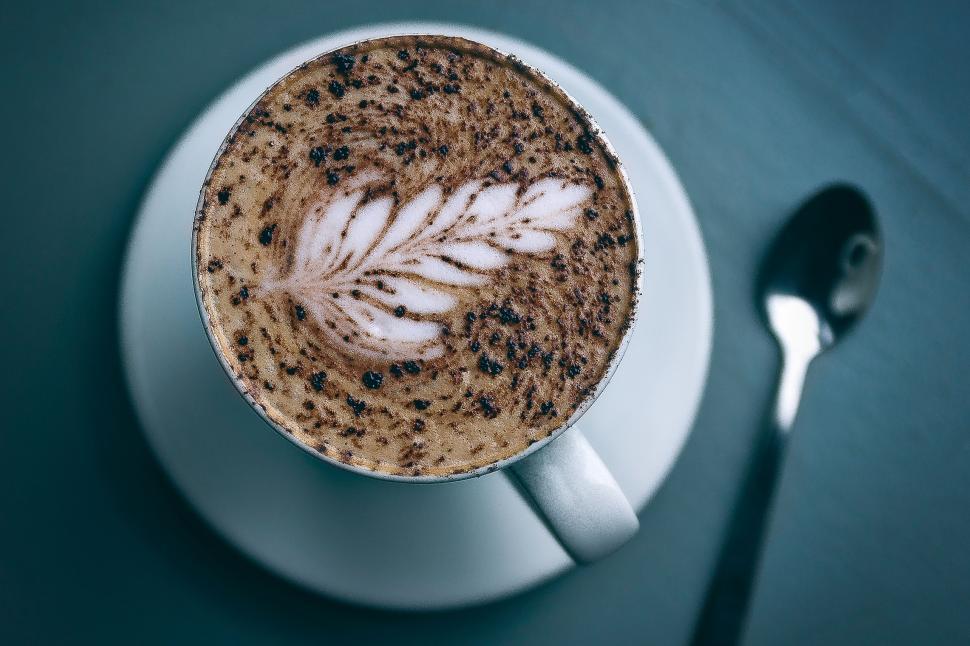 Free Image of Coffee art presented in a white cup with delicate froth design in the morning light 