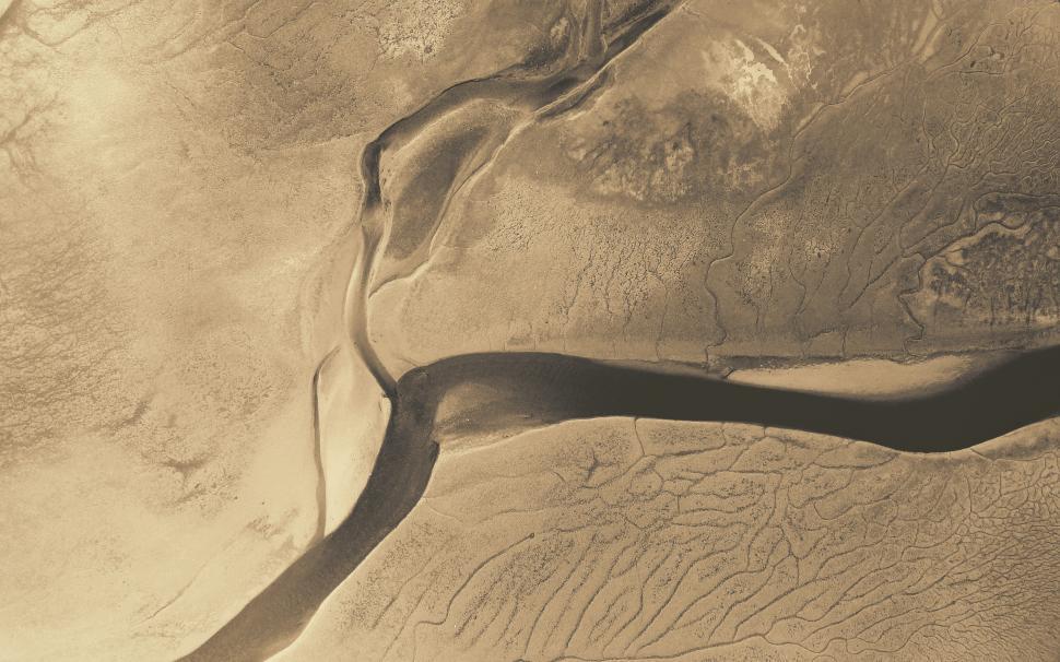 Free Image of Aerial view of winding river crossing arid landscape during golden hour 