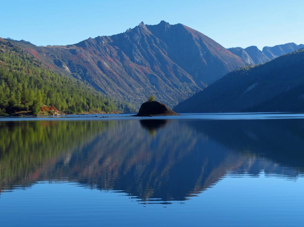 Free Image of Serene mountain lake with clear reflections at dawn 