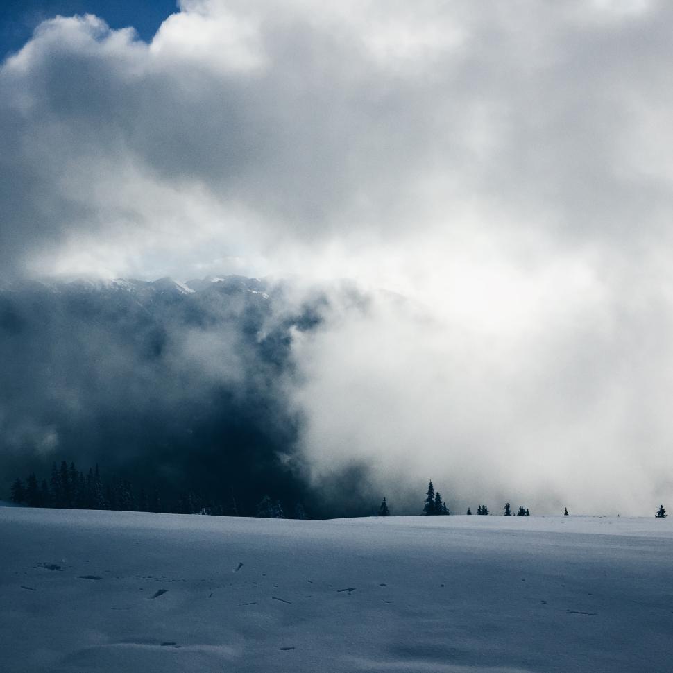 Free Image of Snowy landscape under dramatic clouds in winter 