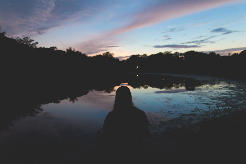 Free Image of Reflections at sunset near a calm pond surrounded by trees 