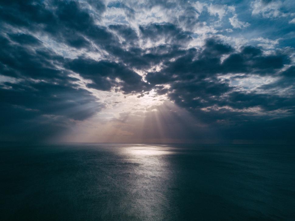 Free Image of Beautiful clouds over shimmering ocean during twilight hours 