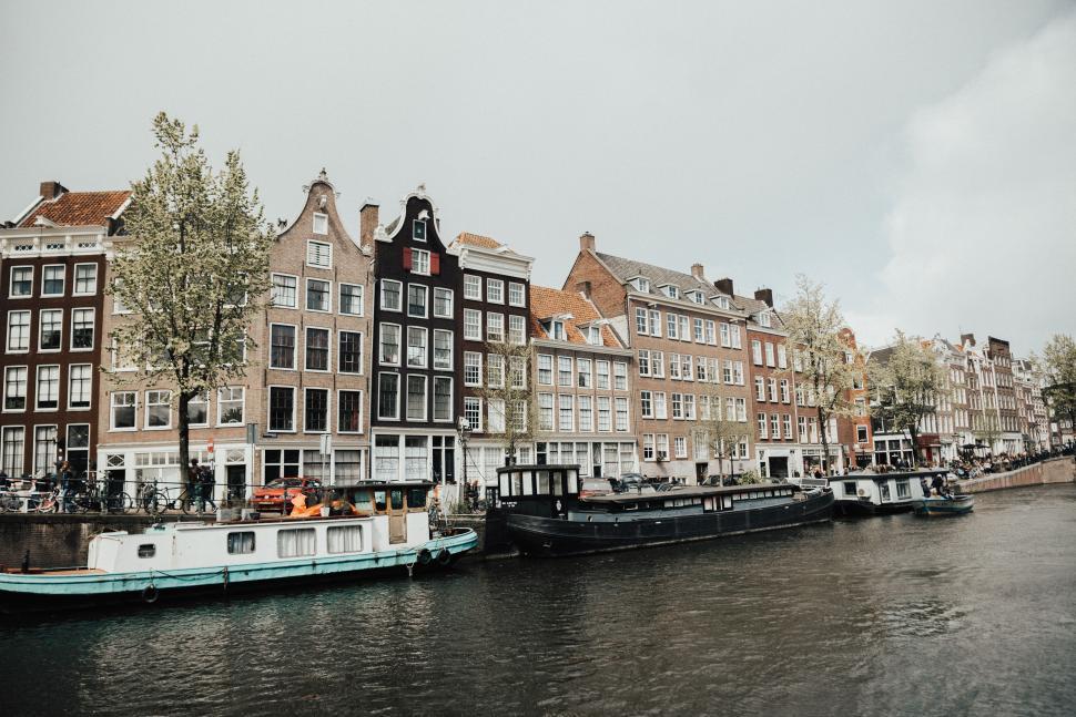 Free Image of Canal houses and boats in Amsterdam during spring 