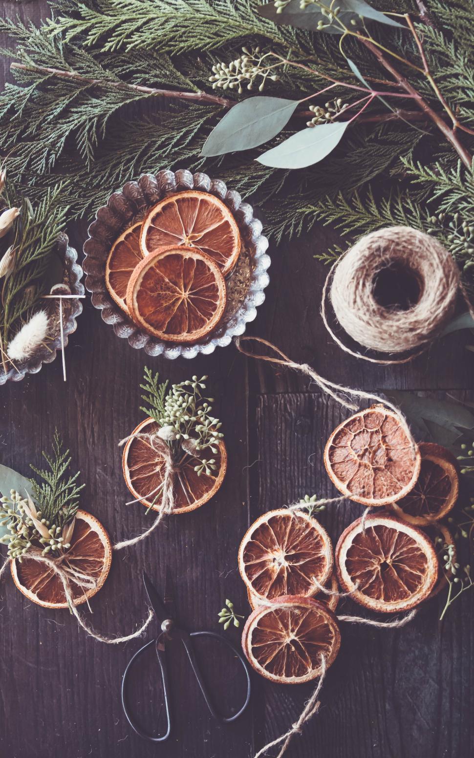 Free Image of Holiday crafting with dried oranges and natural elements 