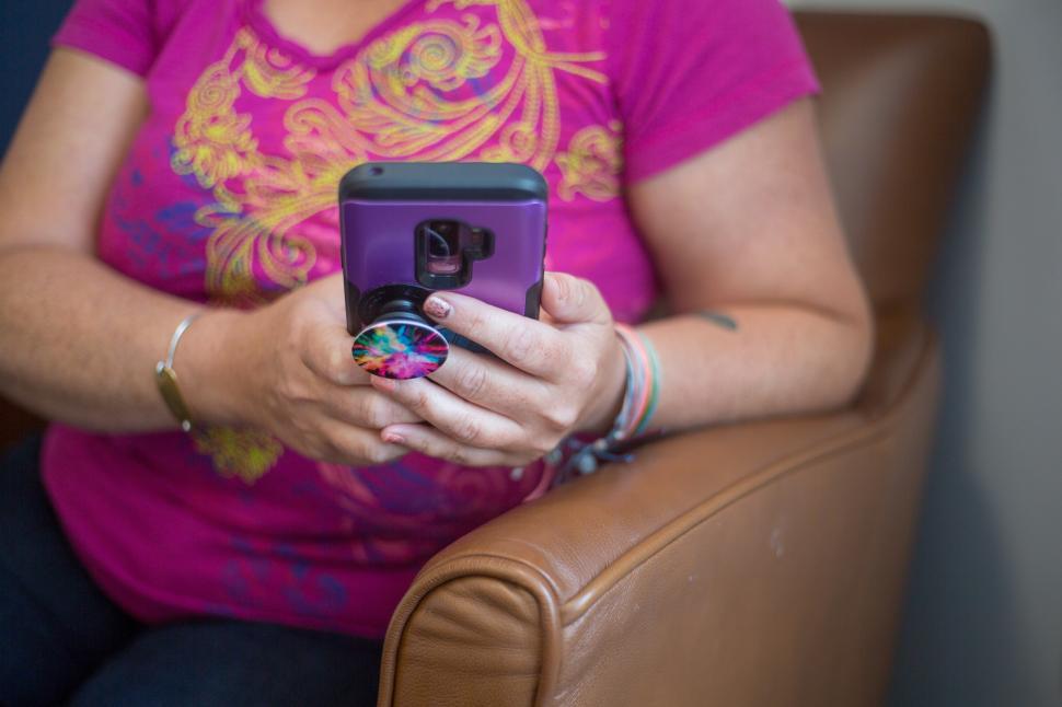 Free Image of Woman using smartphone while sitting in a cozy chair indoors 