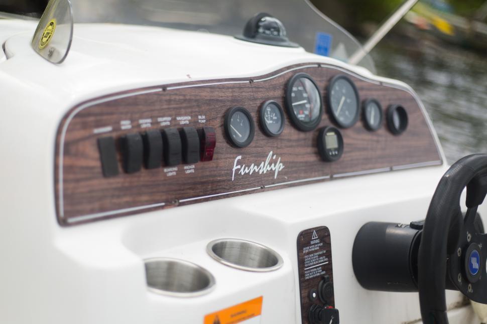 Free Image of Coastal adventures on a boat with functional controls and steering wheel 