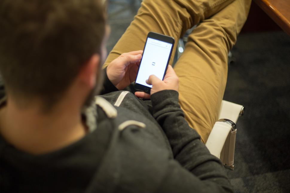 Free Image of Individual using smartphone while seated in office setting 