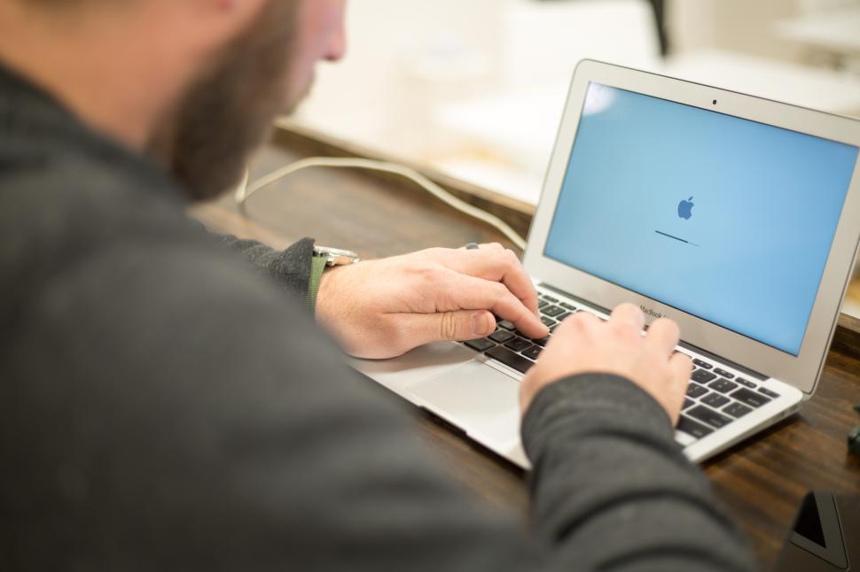 Free Image of Man working on a laptop in a bright indoor space during daytime hours 