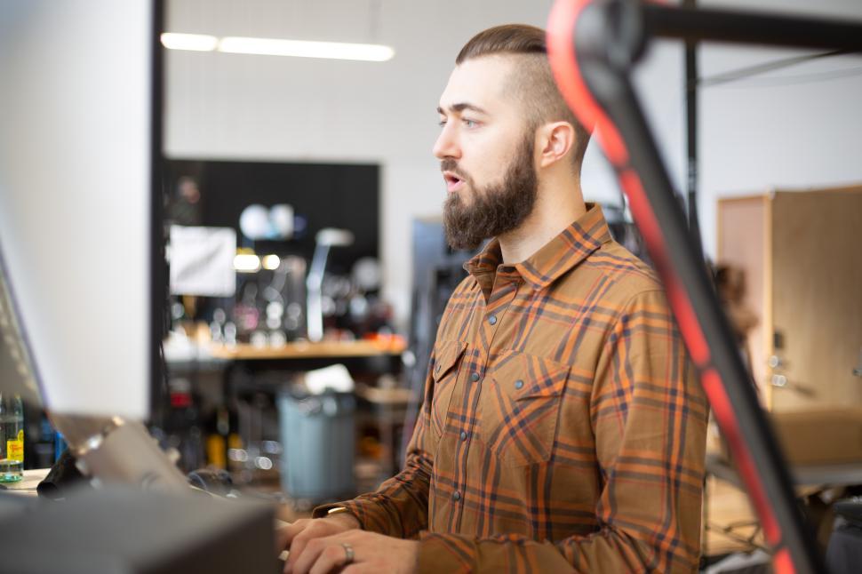 Free Image of Man working at computer in modern workspace during the day 