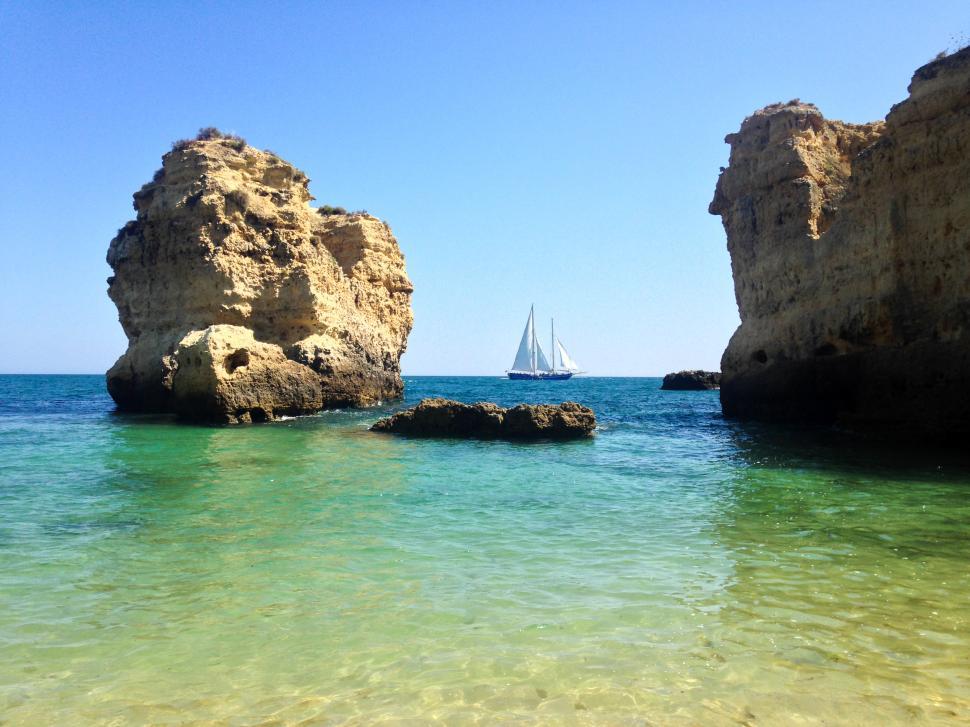 Free Image of Sailing near rock formations in a clear blue sea 