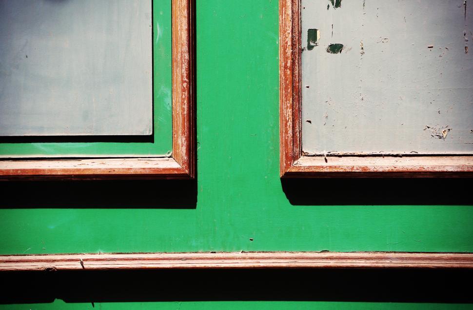 Free Image of Vibrant green wall with decorative frames at urban location 