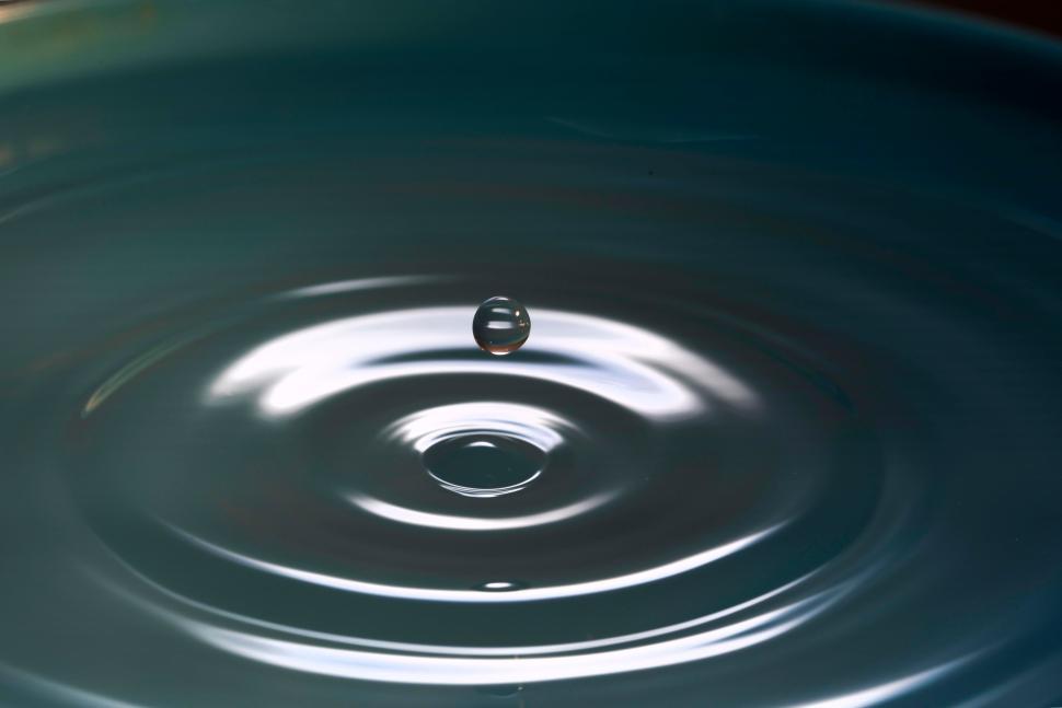 Free Image of Captivating water droplet creating ripples in still surface 
