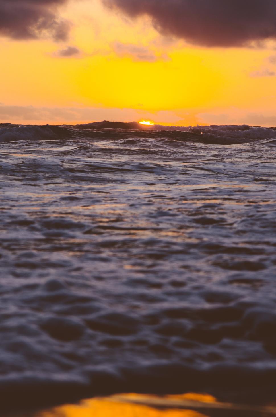 Free Image of Sunset over ocean waves creating a serene atmosphere at twilight 