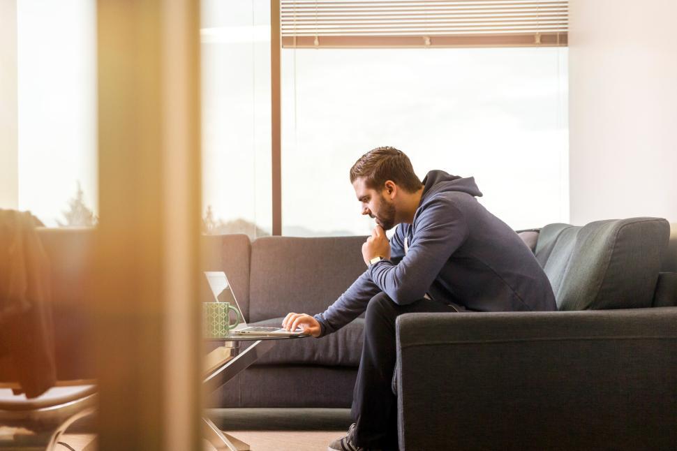 Free Image of Man working on laptop in modern office setting 