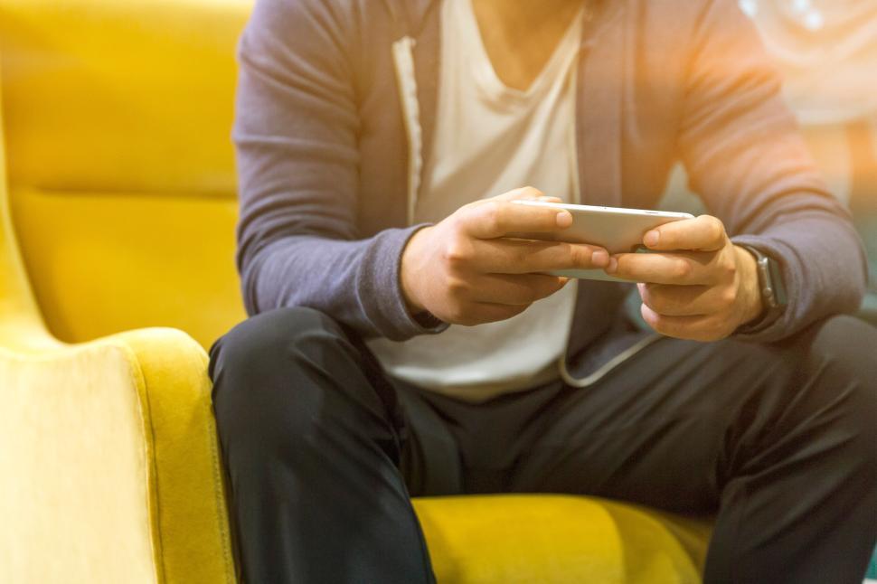 Free Image of Person engaged in mobile gaming in a cozy setting 