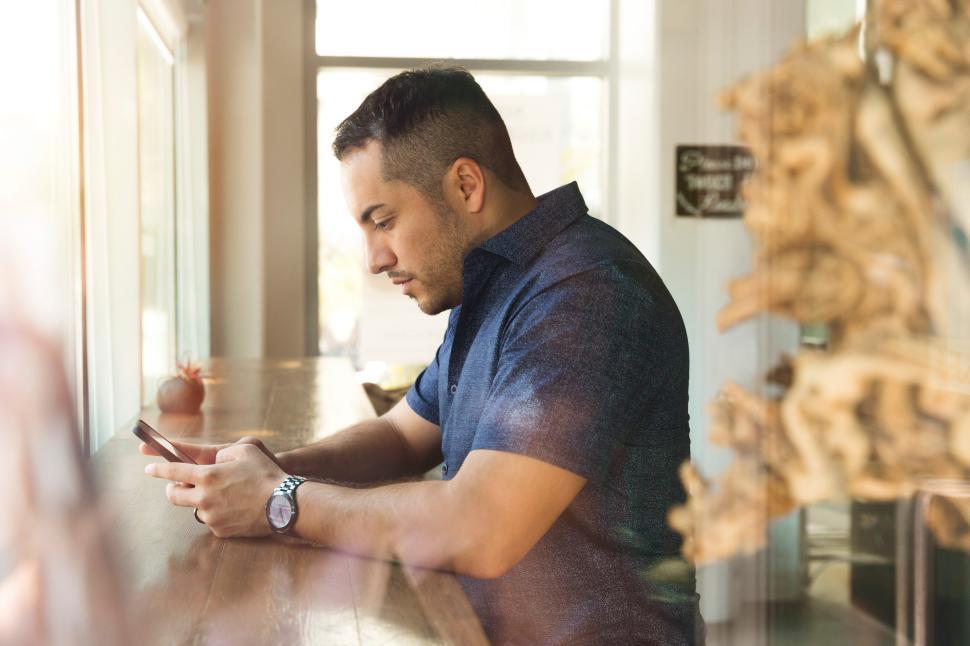 Free Image of Man using smartphone in cafe during daytime hours 