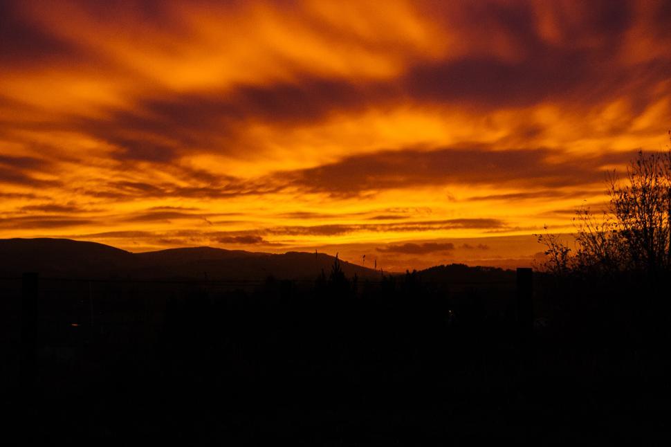 Free Image of Beautiful sunset over mountains with vibrant orange skies 