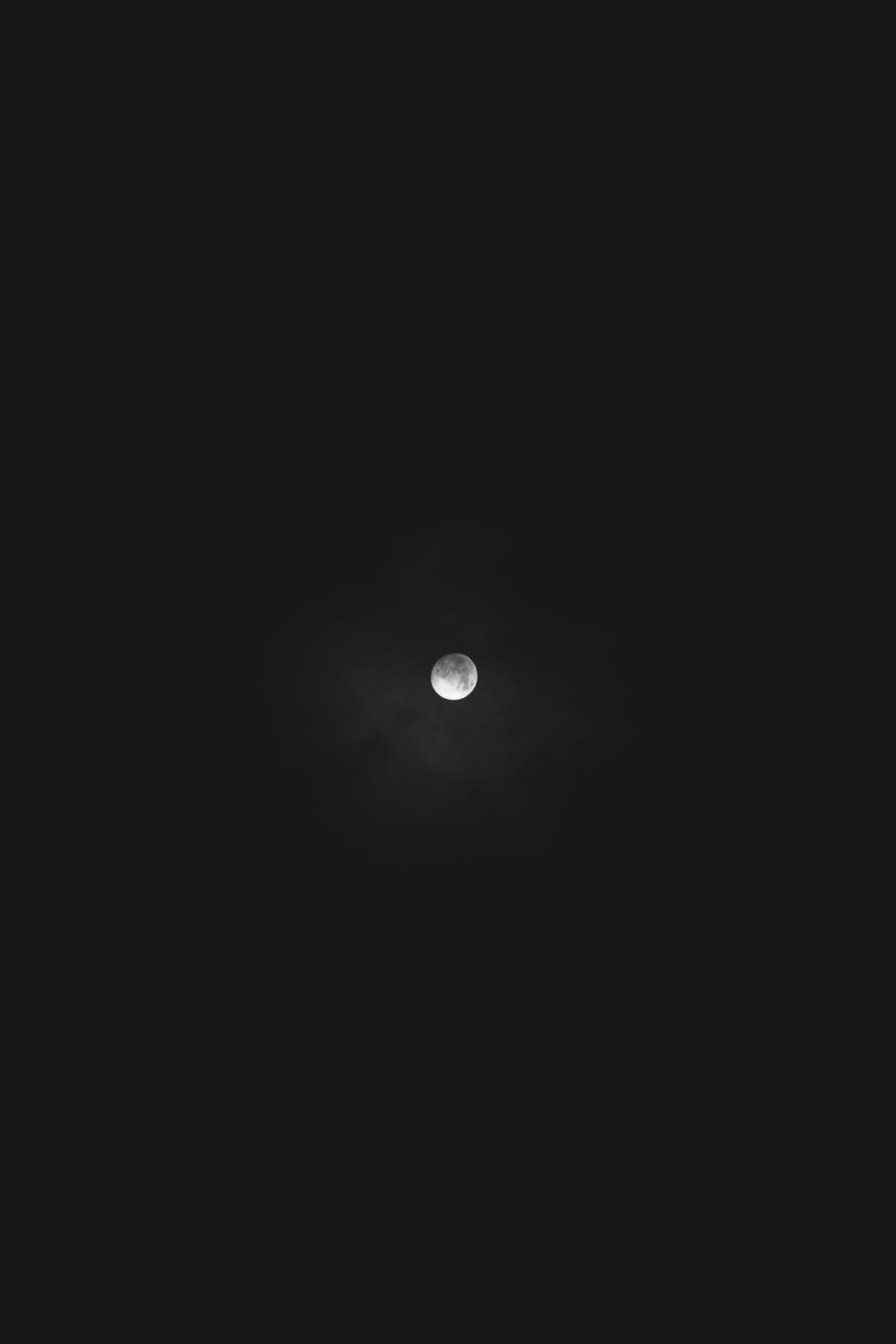 Free Image of Bright moon shining through a dark sky at night 