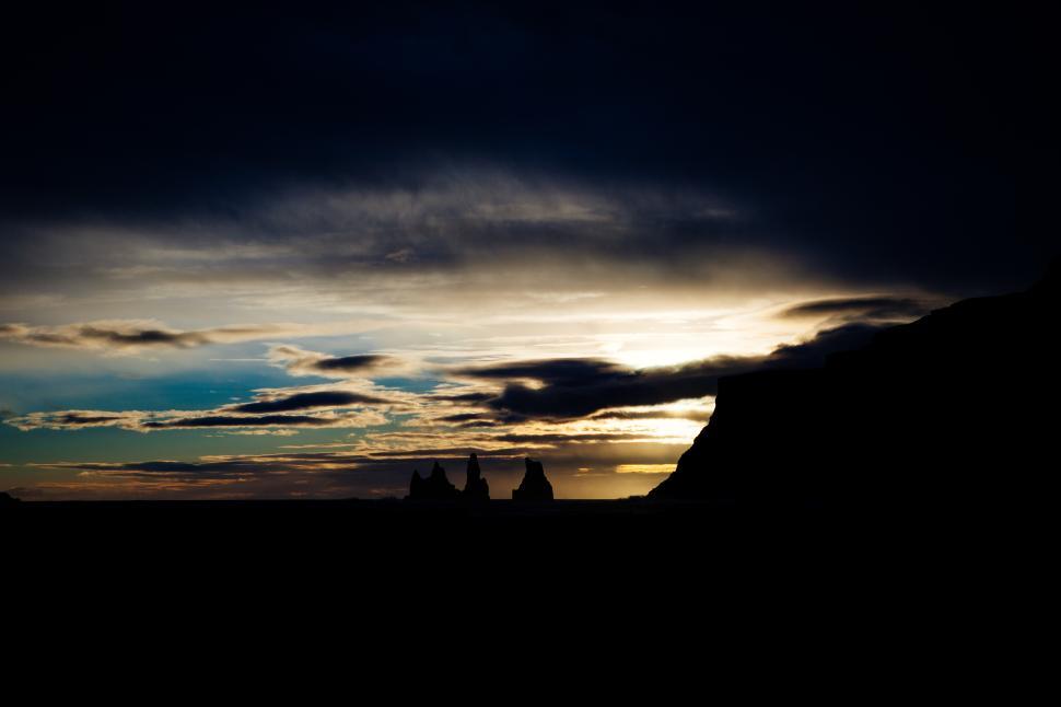 Free Image of Dramatic sunset over silhouettes of rugged cliffs 