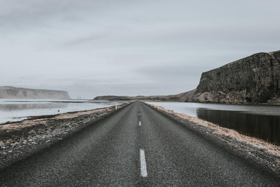 Free Image of Majestic road stretching beside calm water in Iceland 