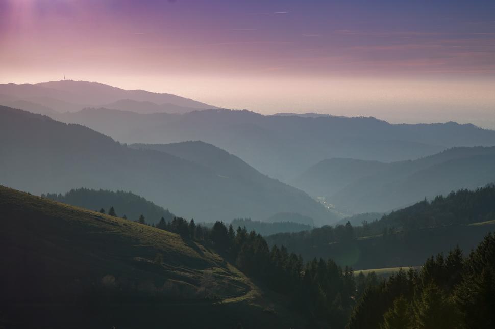 Free Image of Majestic mountain range at twilight with layers of fog and a serene atmosphere 