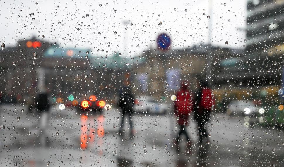 Free Image of Rainy street scene with pedestrians in city center 