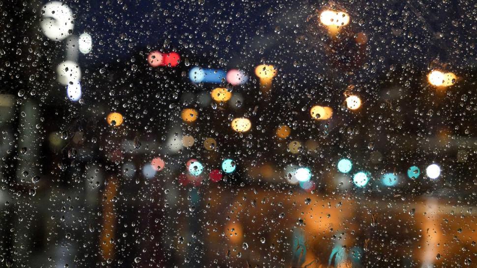 Free Image of Urban night view with raindrops on the window 