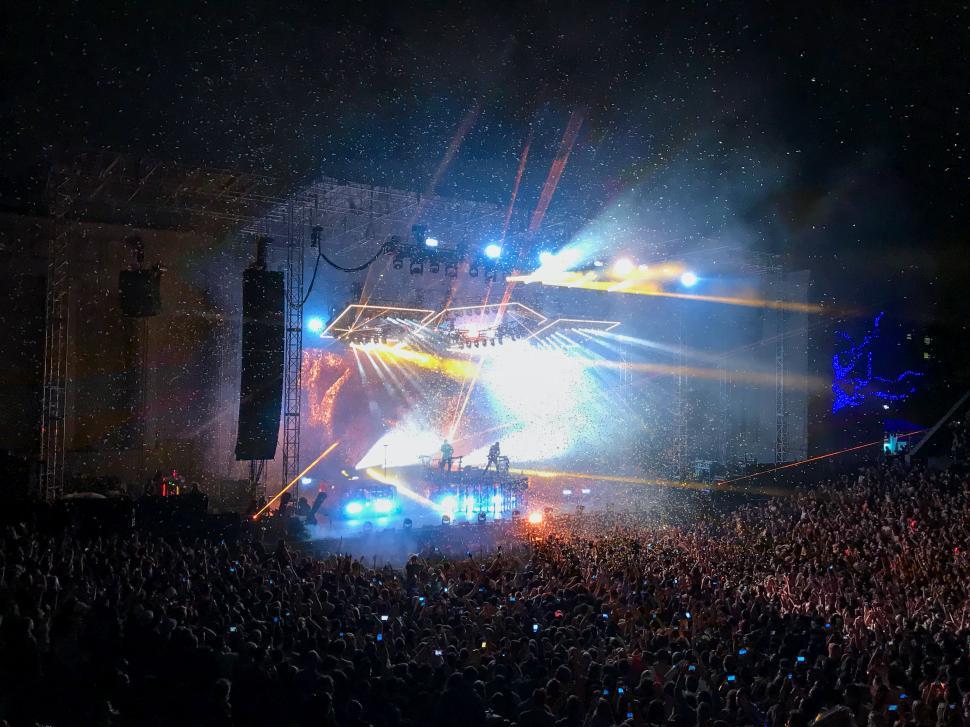Free Image of Crowd celebrates at outdoor concert with dazzling lights and confetti 