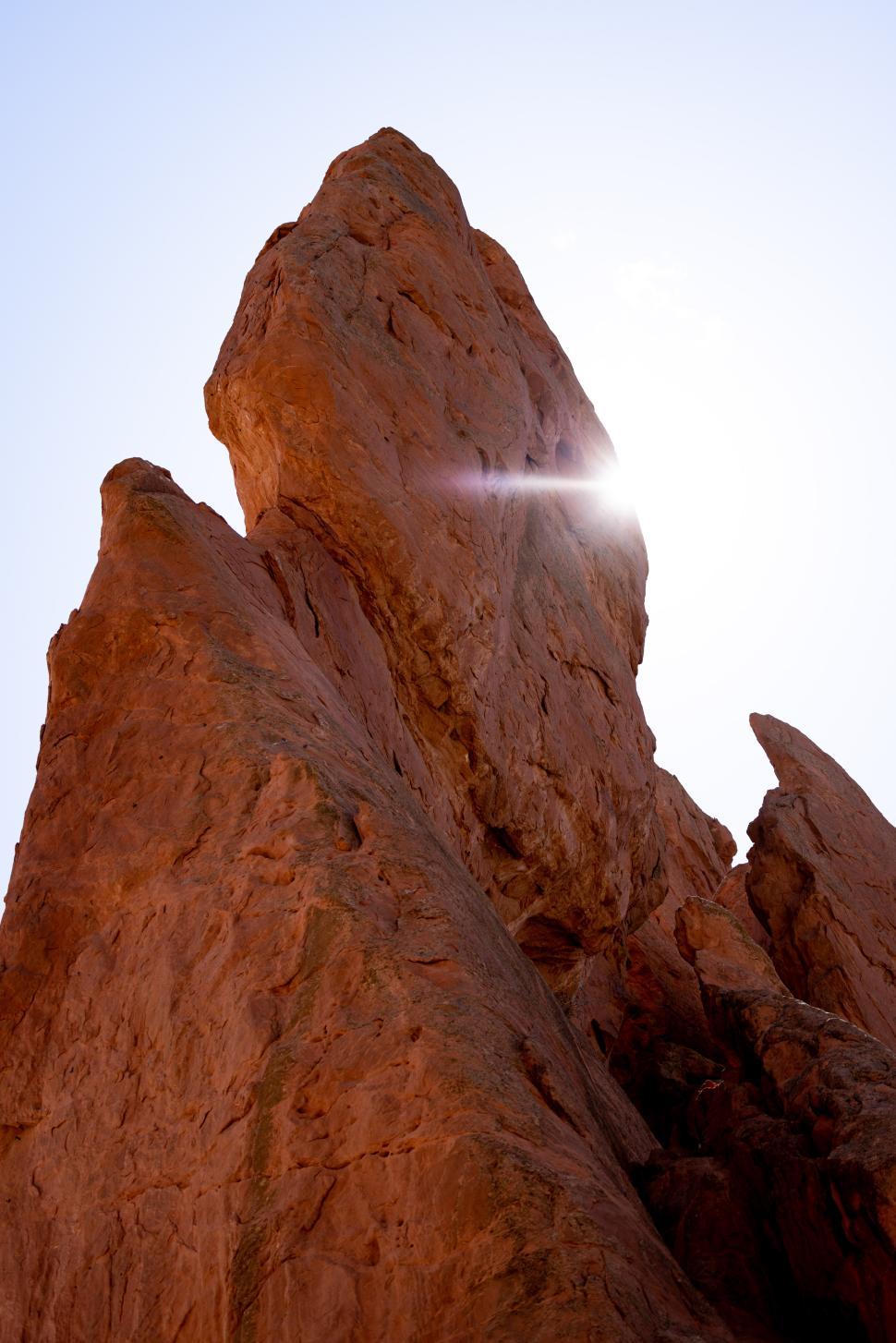 Free Image of Towering rock formation illuminated by sunlight in desert setting 