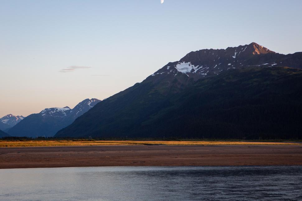 Free Image of Sunset over mountains and river in a serene natural landscape 