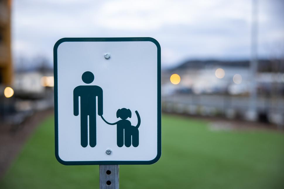 Free Image of Sign indicating dog walking rules by the waterfront park area 