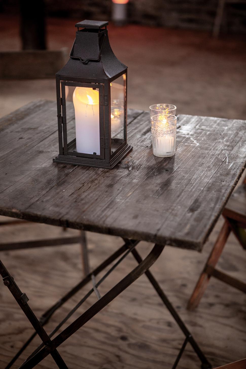 Free Image of Candlelit table with lanterns in a rustic outdoor setting 