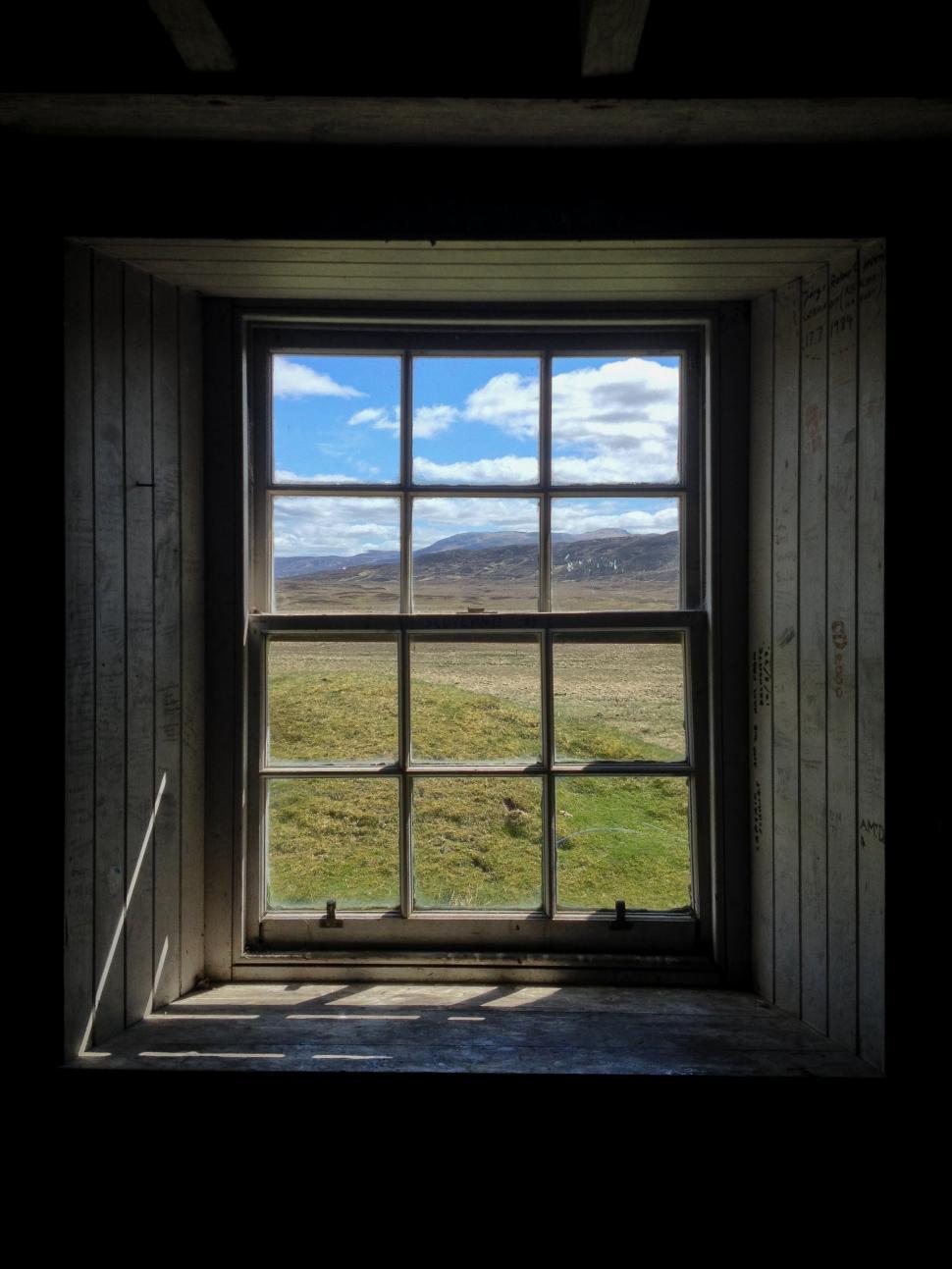 Free Image of Window view of rural landscape with mountains in the distance 