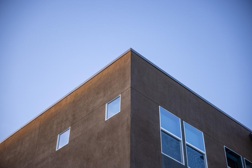 Free Image of Modern building corner under clear blue sky at sunset 