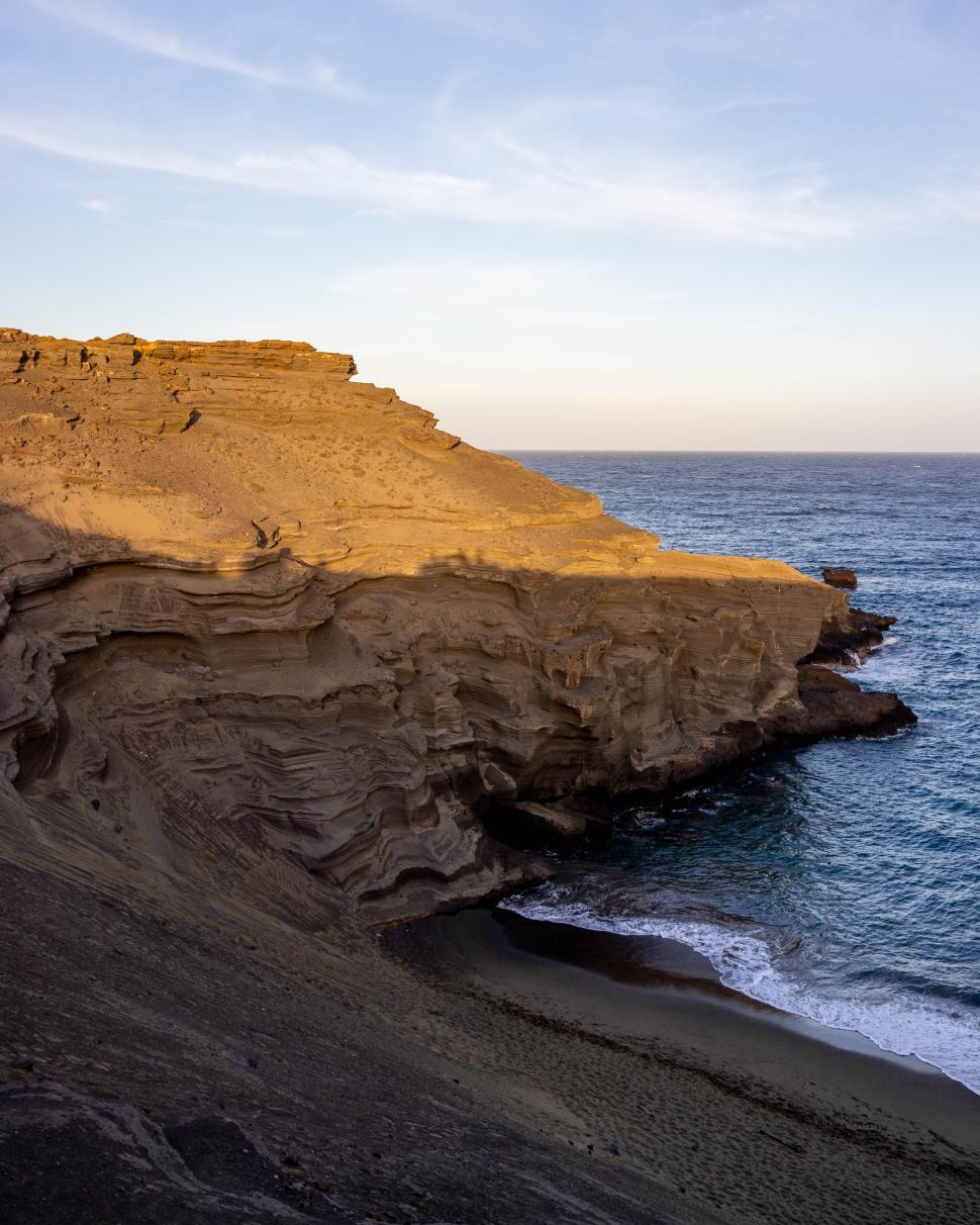 Free Image of Sunset over rocky coastline at remote beach location 
